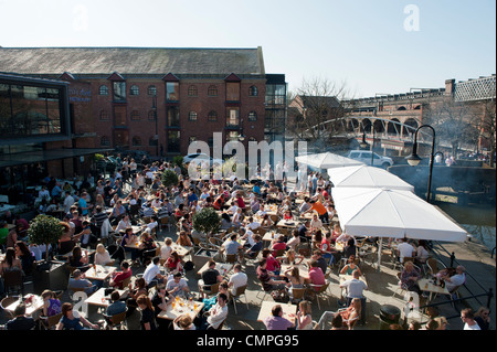 Nachtschwärmer genießen die Abendsonne in einem Biergarten in Castlefield in Manchester (nur zur redaktionellen Verwendung). Stockfoto