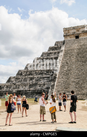 Tempel von Kukulkan El Castillo Chichen Itza Mexiko | CHICHEN ITZA, Mexiko — Touristen versammeln sich am Fuße des Tempels von Kukulkan (El Castillo) in der archäologischen Zone von Chichen Itza. Diese ikonische Pyramide, ein UNESCO-Weltkulturerbe, ist ein herausragendes Bauwerk innerhalb der Ruinen der antiken Maya-Stadt auf der Halbinsel Yucatán in Mexiko. Der Ort zieht Besucher aus aller Welt an, die begierig darauf sind, die reiche Geschichte und die architektonischen Errungenschaften des Maya-Volkes zu erkunden. Der Tempel von Kukulkan ist berühmt für seine astronomischen Ausrichtungen, insbesondere für den Schlangenschatten, der während des Frühlings erscheint Stockfoto