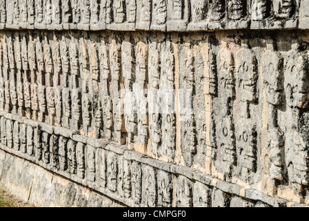 Chichen Itza Skulls Carved Wall Mexico // CHICHEN ITZA, Mexiko — Darstellung von Schädeln, die in einer Steinmauer in Chichen Itza, Mexiko, gemeißelt wurden. Stockfoto