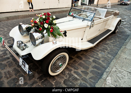 restaurierte Oldtimer SS Typ V Jaguar Limousine mit schönen Blumenstrauß Rosen auf Motorhaube Parken auf der Straße warten Braut & Bräutigam Oaxaca Stockfoto