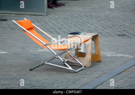 Orange, entspannenden Liegestuhl auf gepflasterten Straße in Belgien Stockfoto