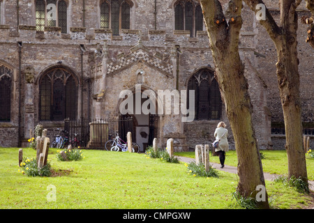 Eine Frau, die zu Fuß in Richtung einer Kirchentür, Kirche von St. Andrew, Soham, Cambridgeshire UK Stockfoto