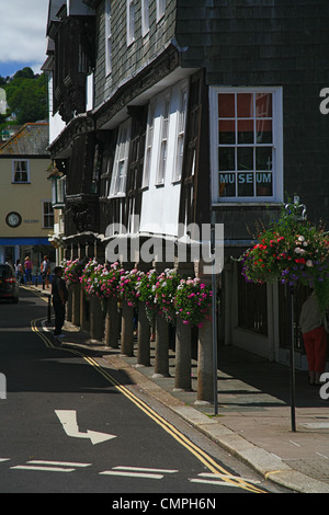 Der historische Butterwalk Arcade mit seinen bunten Blumenampeln in Dartmouth, Devon, England, UK Stockfoto