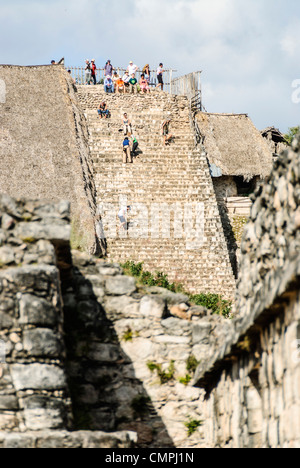 Maya EK Balam Akropolis Touristen klettern Yucatan Mexiko // EK' BALAM, Mexiko - Touristen klettern die steilen Kalksteinstufen der Akropolis, die größte Struktur an der archäologischen Stätte EK' Balam (auch bekannt als Ek Balam). Die 31 Meter hohe (96 Fuß hohe) Pyramide ist nach wie vor eines der wenigen Maya-Bauten in der Yucatán, die Besucher noch besteigen dürfen. Dieser riesige Komplex diente als königlicher Palast von König Ukit Kan Le'k Tok', der das alte Königreich Talol ab 770-797 n. Chr. regierte. Zwischen Valladolid und Cancún im Norden von Yucatán gelegen, nimmt das Gelände weniger Besucher auf als in der Nähe Stockfoto