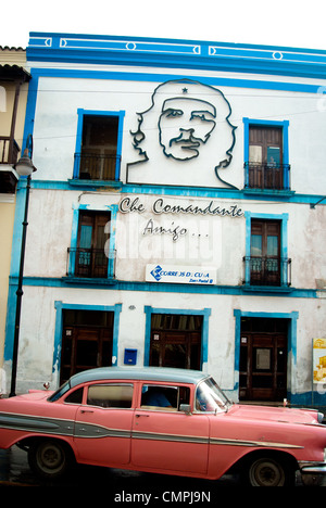 Bild von Ernesto Che Guevara auf das Gebäude und ein altes Auto vorbei Stockfoto