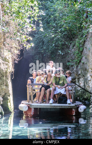 PLAYA DEL CARMEN, Mexiko – Touristen fahren mit einem Boot durch die schmalen Flüsse, die durch den Xcarat Maya Freizeitpark südlich von Cancun und Playa del Carmen auf der mexikanischen Halbinsel Yucatana verlaufen. Stockfoto