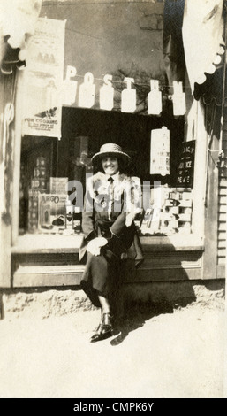 Ca. 1910er Jahre Snapshot einer Frau vor einen kleinen Supermarkt, ein Zeichen für Postum. Stockfoto