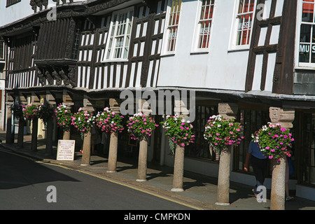 Der historische Butterwalk Arcade mit seinen bunten Blumenampeln in Dartmouth, Devon, England, UK Stockfoto