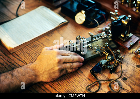 1890S 1900S MANN HAND TELEGRAFIST IN EISENBAHN-BÜRO Stockfoto