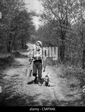 1950ER JAHRE JUNGE BEAGLE WELPEN HINUNTER LANDSTRAßE PFEIFEN TRAGEN FISCHEREI POLE EIMER FISCH Stockfoto