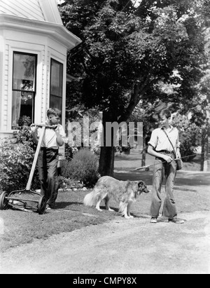 1940ER JAHRE JUNGE MIT FISHING GEAR COLLIE HUND ZWEITE JUNGE MÄHEN RASEN MIT PUSH-MÄHER Stockfoto