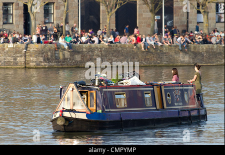 Ein Hausboot reist durch die Hafenpromenade von der Arnolfini Galerie in Bristol. Das Zentrum ist ein kultureller Hotspot der Stadt. Stockfoto