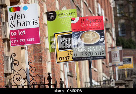 Für Verkauf und Zeichen außerhalb von Reihenhäusern in Bristol an einem sonnigen Tag zu lassen. Lokale Immobilienmakler Werbung Eigenschaften. Stockfoto