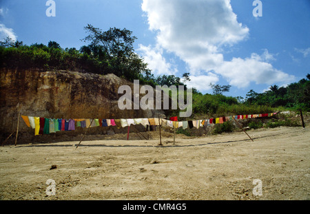 Eine lange Reihe von Multi-farbige Wäsche hängt auf einer Linie trocknen in der Sonne auf einem Sandstrand, Poneloya, Nicaragua Stockfoto