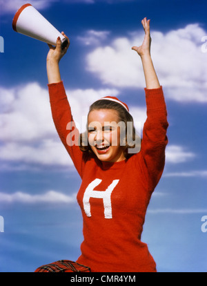 1940s 1950s TEENAGE GIRL CHEERLEADER roten Pullover mit ihren Armen IN AIR HOLDING Megaphon Stockfoto