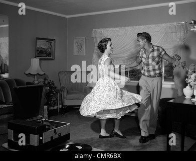 1950S 1960S JITTERBUG TEEN PAARE TANZEN IM WOHNZIMMER Stockfoto