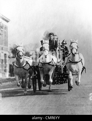 1890S 1900S OLD-TIME FRONTALEN SCHUSS VON PFERDEN GEZOGENEN FIRE TRUCK RACING DOWN STREET Stockfoto