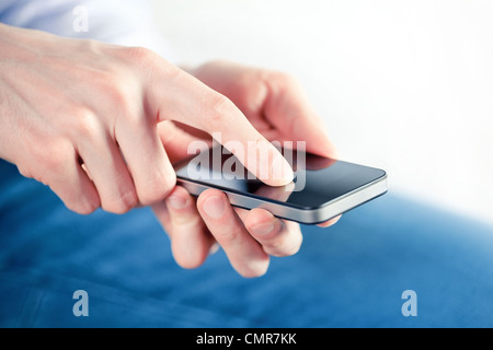 Hand des Menschen berühren Bildschirm auf moderne mobile smart Phone. Nahaufnahme Bild mit flachen Feld Schärfentiefe am Finger. Stockfoto