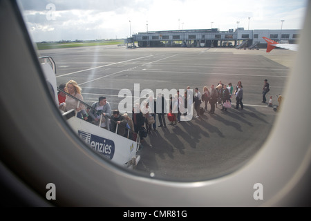 mit Blick auf die lange Schlange von Fluggästen Easyjet-Flugzeuge am Flughafen Belfast Nordirland Vereinigtes Königreich. Stockfoto