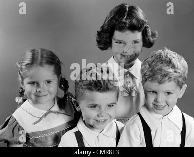 1950ER JAHRE PORTRÄT VON VIER LÄCHELNDEN KINDER ZWEI JUNGEN UND ZWEI MÄDCHEN Stockfoto