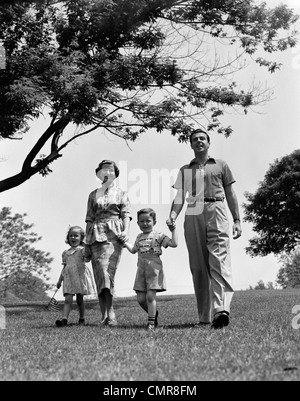 1950ER JAHREN GLÜCKLICHE FAMILIE MUTTER VATER TOCHTER SOHN WANDERN IM PARK Stockfoto