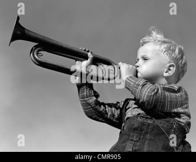 1940ER JAHRE JUNGE BLÄST TROMPETE IM FREIEN Stockfoto