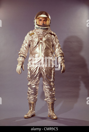 1960ER JAHREN STEHEN IN VOLLER LÄNGE PORTRAIT ASTRONAUT IN SILBER RAUMANZUG UND HELM Stockfoto