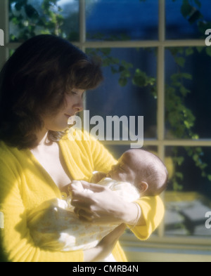 1970ER JAHREN MUTTER NEUGEBORENES BABY FENSTER HALTEN Stockfoto