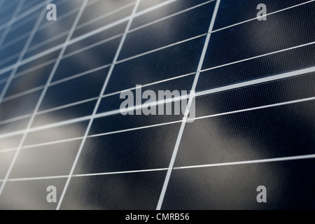 Voltaische Fotoplatten sammeln Energie aus der Sonne. Wolken spiegeln sich im Panel. Vertikale Zusammensetzung. Stockfoto