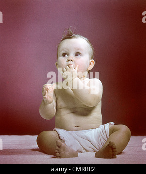 1940S 1950S BABYSITTING WINDEL NACHSCHLAGEN FINGER IM MUND Stockfoto