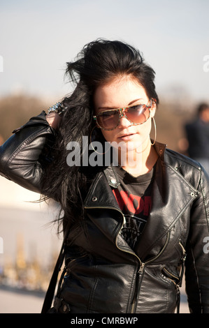 Junge Frau mit langen schwarzen Haaren tragen Lederjacke, hand aufs Haar. Stockfoto