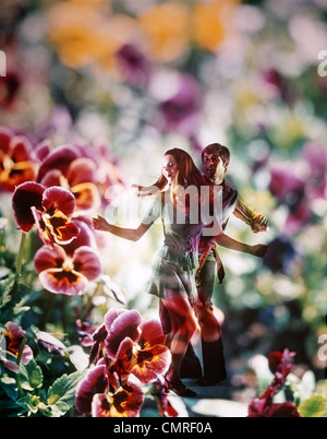 1960S 1970S JUNGES PAAR TANZEN UNTER STIEFMÜTTERCHEN BLUMEN GRAFISCHEN EFFEKT ÜBERLAGERT Stockfoto