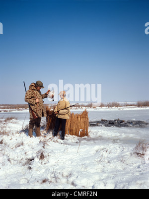 1970ER JAHREN VATER UND SOHN ENTE JAGD IM WINTER SCHNEE DEEP CREEK, VA Stockfoto