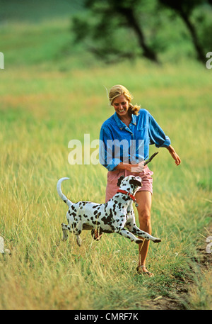 1990ER JAHRE BLONDE FRAU UND DALMATINISCHEN IM FREIEN Stockfoto