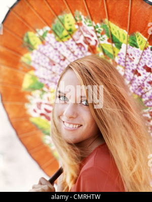 1960S 1970S LÄCHELN AUF DEN LIPPEN BLONDE FRAU PORTRAIT MIT ORANGE PRINT JAPANISCHEN SONNENSCHIRM Stockfoto