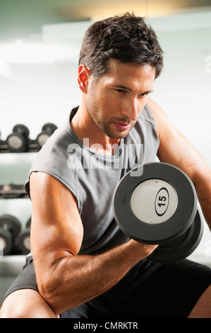 Gemischte Rassen Mann Aufhebung Hanteln im Fitnessstudio Stockfoto