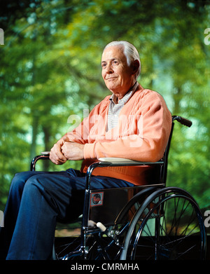 1970ER JAHRE LÄCHELNDER ÄLTERER SENIOR MANN SITZEN ROLLSTUHL RETRO Stockfoto