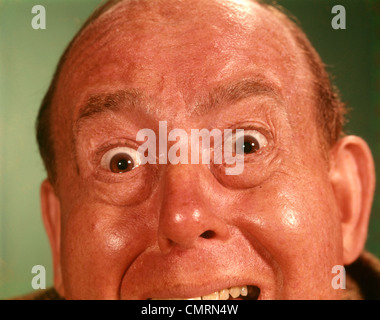1960 1960S PORTRAIT MANN STIRN BIS ZUM KINN DUMME VERRÜCKTE LUSTIGE MIMIK GROßE AUGEN OFFENEN MUND VERRÜCKT WÜTEND VERÄRGERT ZORNIGEN Stockfoto
