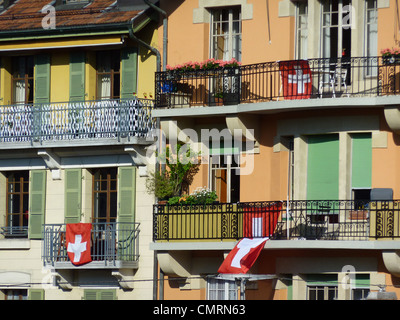Schweizer Fahnen hängen alte Gebäude Balkone und Sonnenlicht, Genf, Schweiz Stockfoto