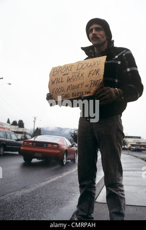 MANN AM STRAßENRAND HOLDING ANFORDERN WORK ZEICHEN Stockfoto