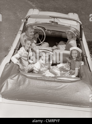 1960ER JAHRE FAMILIE PORTRAIT VATER MUTTER SOHN ZWEI TÖCHTER IM CABRIO IM FREIEN BLICKTE ZU KAMERA Stockfoto