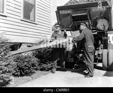 1930S 1940S KOHLE-LKW MIT ZWEI SERVICE MÄNNER MAKING HOME DELIVERY KOHLEFALLSCHACHT IN KELLER Stockfoto