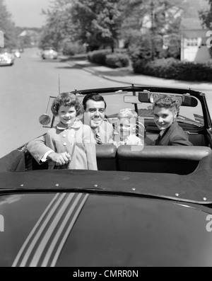 PORTRÄT DER 1950ER JAHRE GUT GEKLEIDET FAMILIE MUTTER VATER SOHN TOCHTER IM CABRIO VERDECK BLICK IN DIE KAMERA ÜBER DER RÜCKSEITE DES RUMPFES Stockfoto