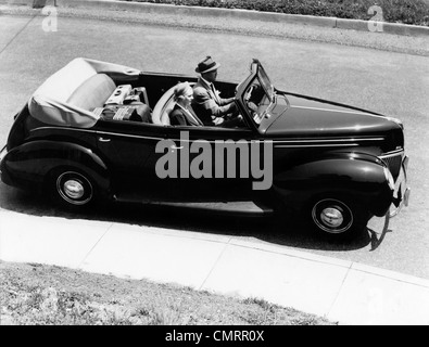 1930S 1940S PAAR MANN UND FRAU 1938 CABRIO VIERTÜRIGE LIMOUSINE KRAFTFAHRZEUG MIT GEPÄCK IM SITZ ZURÜCK Stockfoto