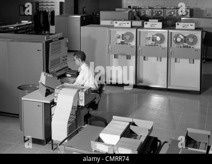 1960ER JAHRE MANN GROßEN MAINFRAME-COMPUTER DATEN BAND UMGEBEN PROGRAMMIERUNG FÄHRT INDOOR Stockfoto