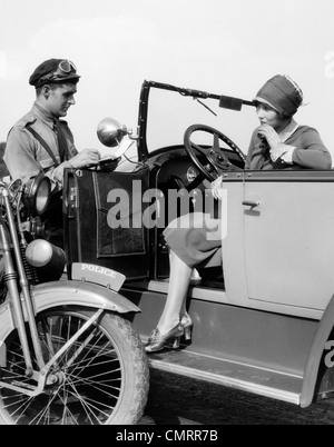 1920ER JAHREN FRAU IM AUTO IMMER VON MOTORRAD-POLIZISTEN TICKET Stockfoto