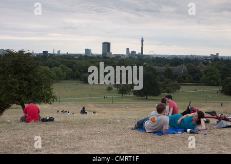 Leute sitzen, genießen die Aussicht vom Primrose Hill, London. Stockfoto