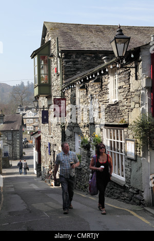 Paar vorbeigehen Sheilas Cottage Restaurant entlang The Slack in Ambleside, Cumbria, NW England, UK Stockfoto