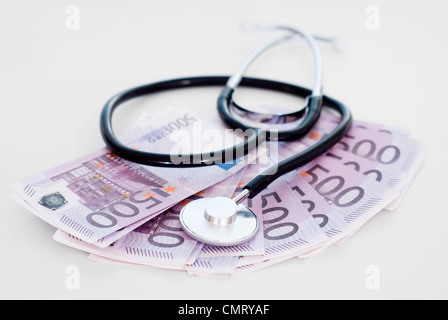 Stethoskop mit Haufen von EURO auf grauem Hintergrund Stockfoto
