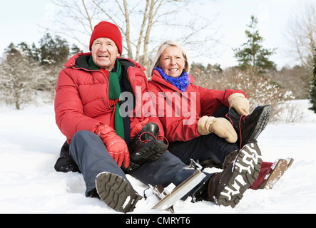 Mann und Frau sitzen im Freien im Schnee Stockfoto